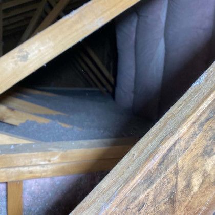 A close up of a wooden structure with a staircase in the background.