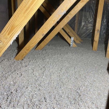 A room with a lot of wooden beams and a carpet on the floor