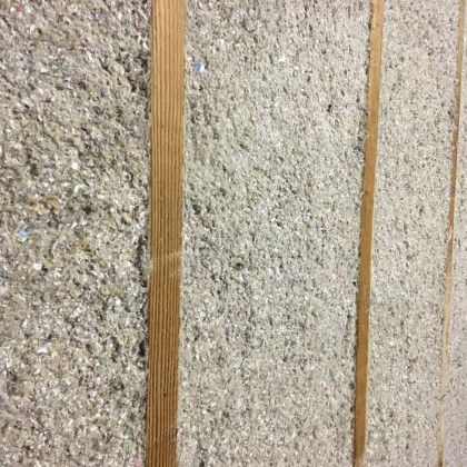 A close up of a concrete wall with wooden beams.