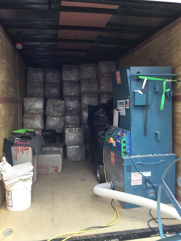 The inside of a truck filled with boxes and a machine.