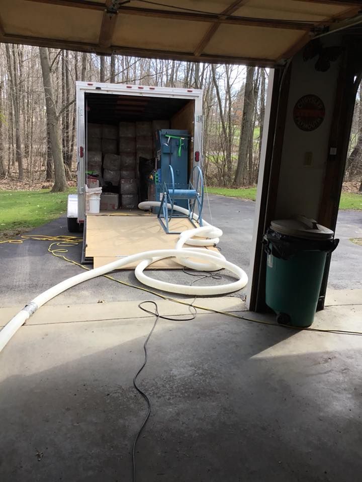 A trailer filled with boxes is parked in a garage.