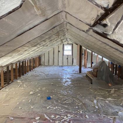 An attic with a lot of foam on it and a window.