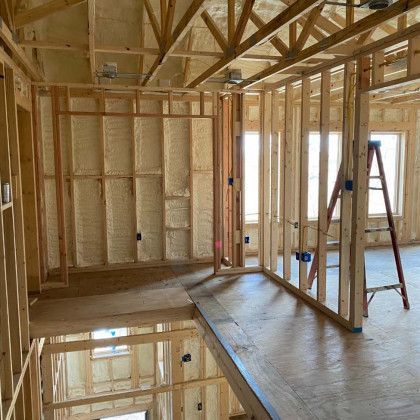 A room in a house under construction with a ladder on the floor.