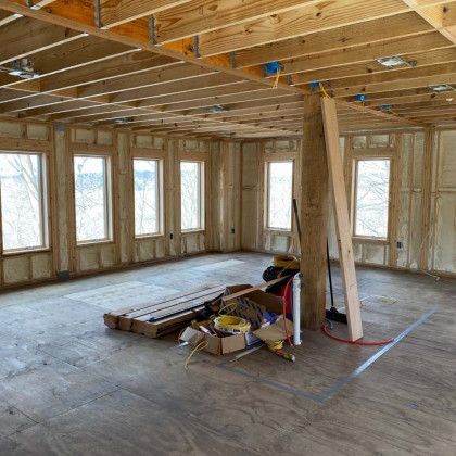 A large room with a lot of windows and wooden beams.