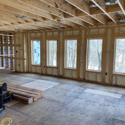A large room with a lot of windows and wooden beams.