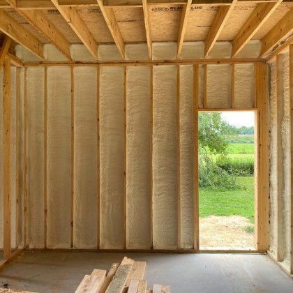 A room with foam insulation on the walls and a door.
