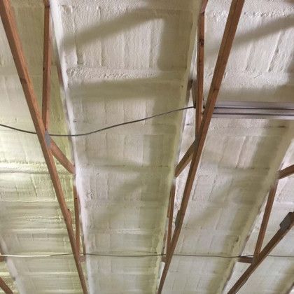 A ceiling with a lot of foam on it and wooden beams.