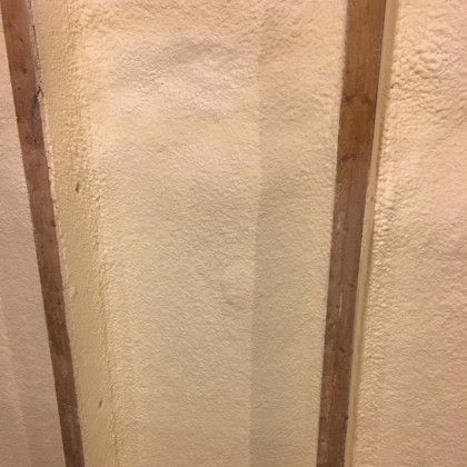 A close up of a wall with foam and wooden beams.