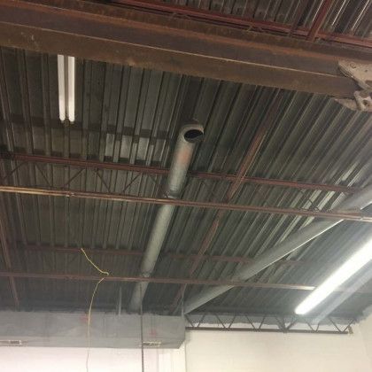 There is a pipe hanging from the ceiling of a building.