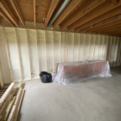 There is a table in the middle of the room covered in plastic.