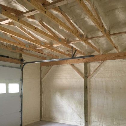 A garage with a garage door and a ceiling covered in foam.
