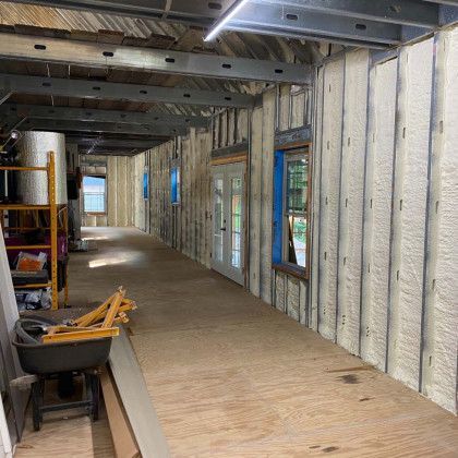 A long hallway in a building under construction with foam insulation on the walls.