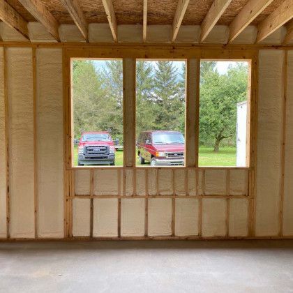A room with a lot of windows and a red truck parked in the background.