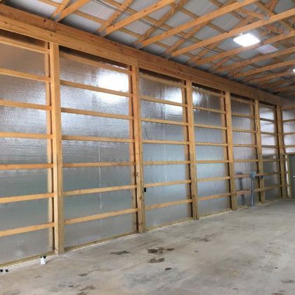 A large warehouse with a lot of wooden walls and a ceiling.