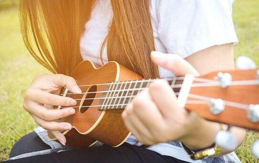 Young Woman Playing on Ukelele — Instrument rentals in Ogden, UT