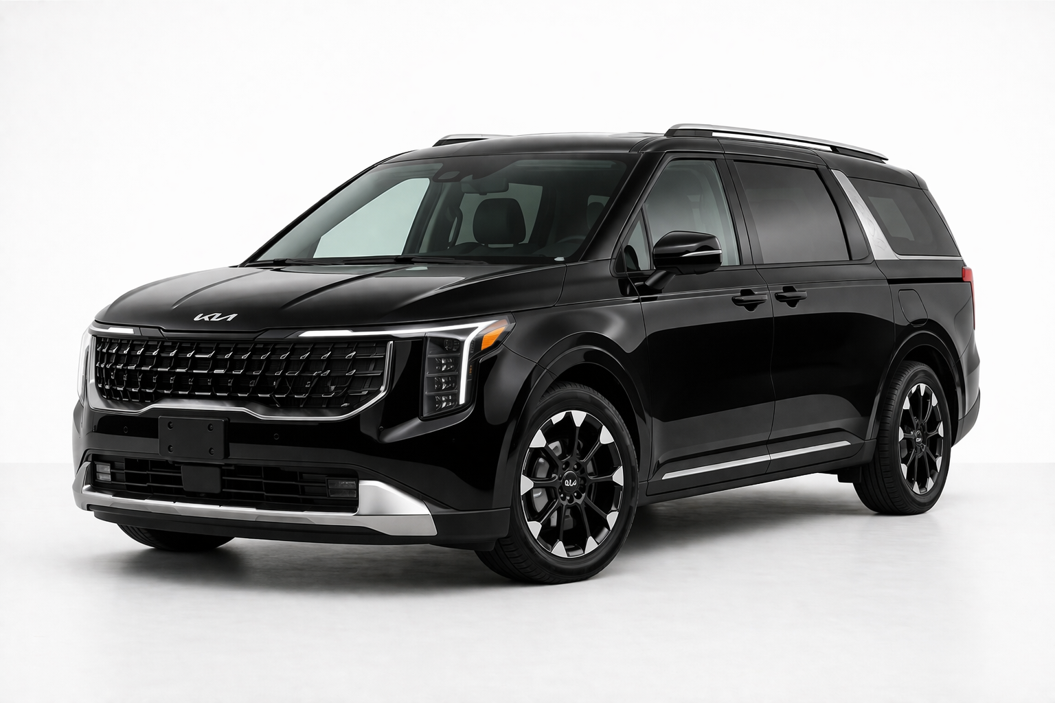 A black Kia Carnival minivan parked against a plain white background.