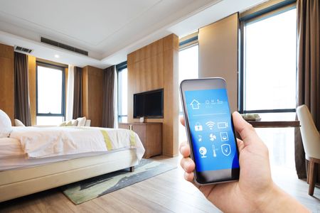 A person is holding a smart phone in a hotel room