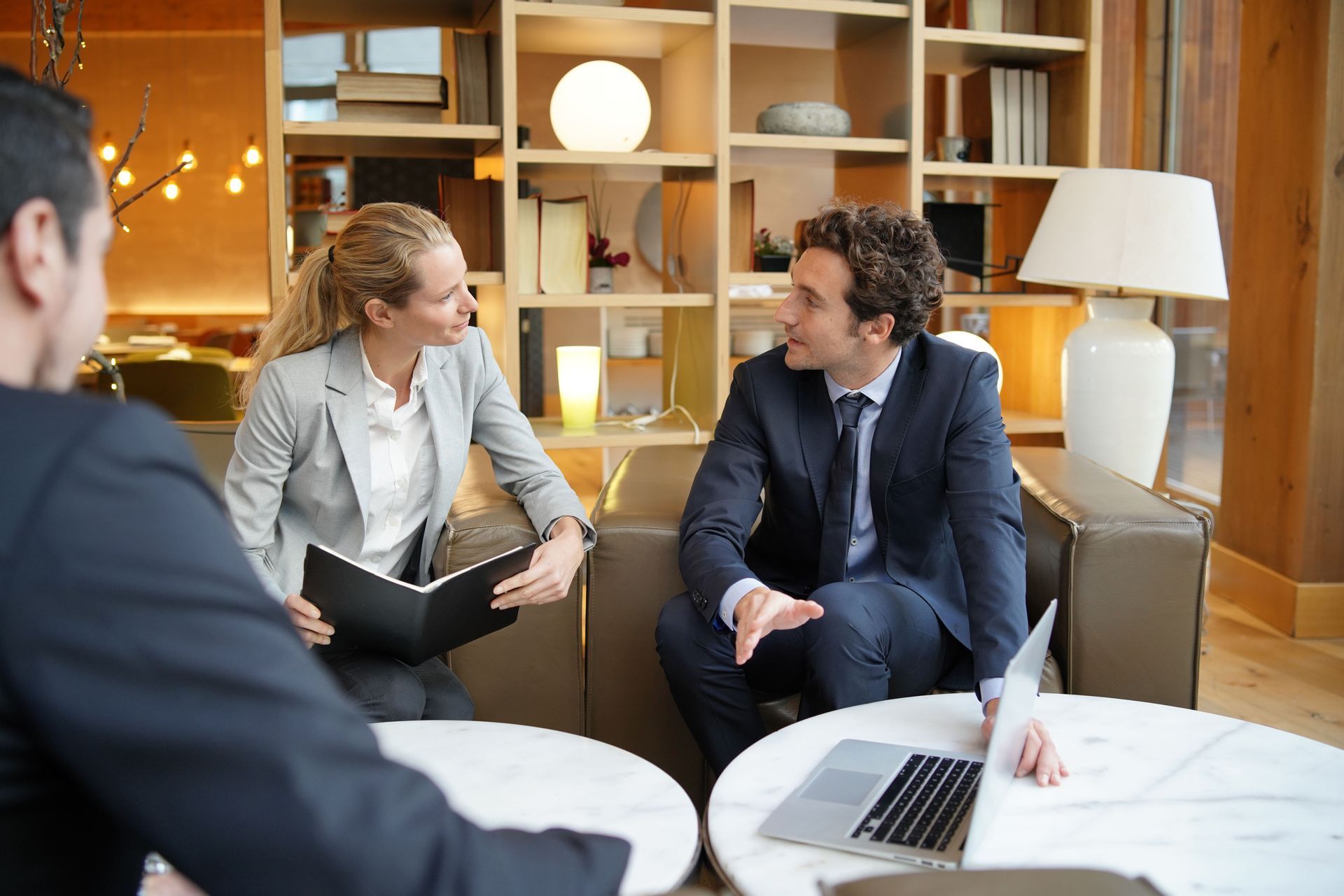 A man and a woman are sitting at a table with a laptop