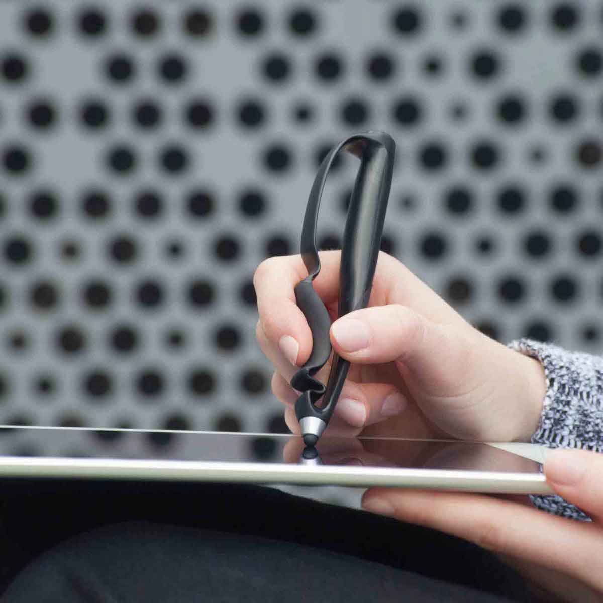 A closeup of a person using a the Scriba Stylus and a tablet.