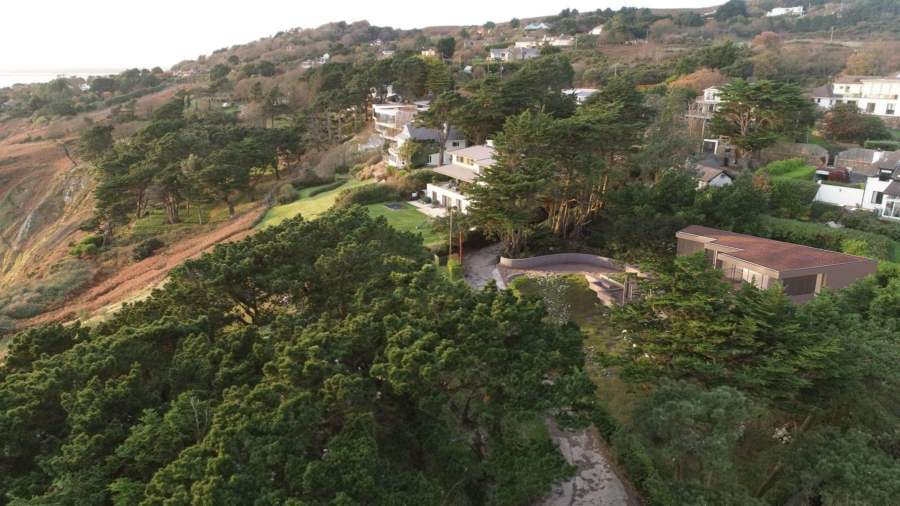 An aerial view of a house on top of a hill surrounded by trees.