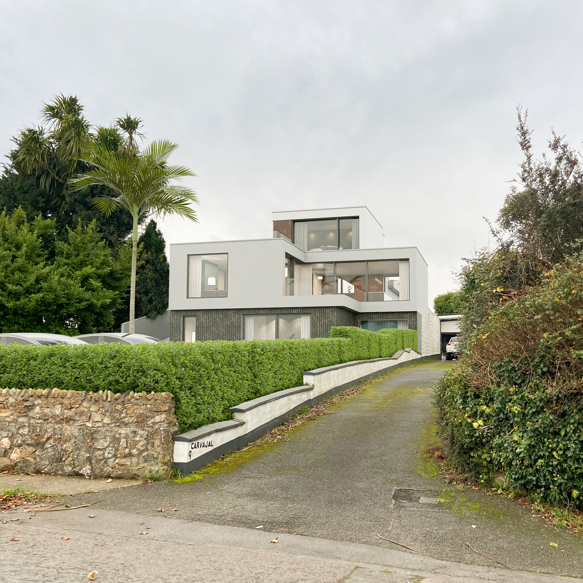 A large white house is surrounded by trees and bushes