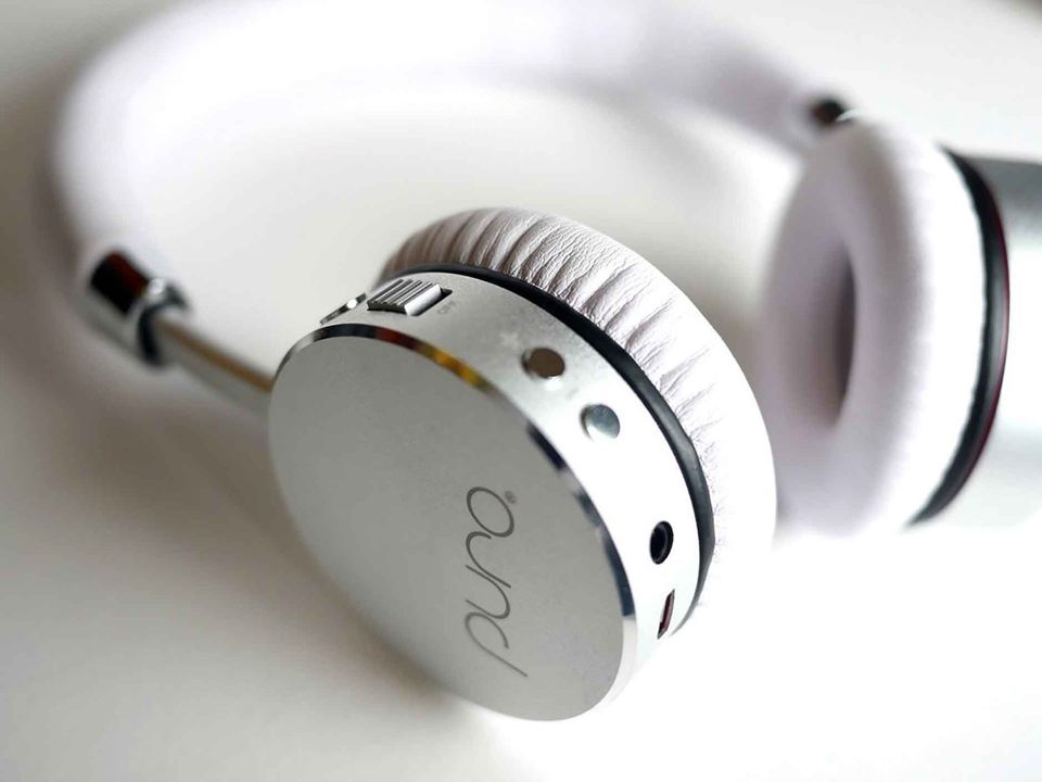 A set of white headphone of the brand Puro