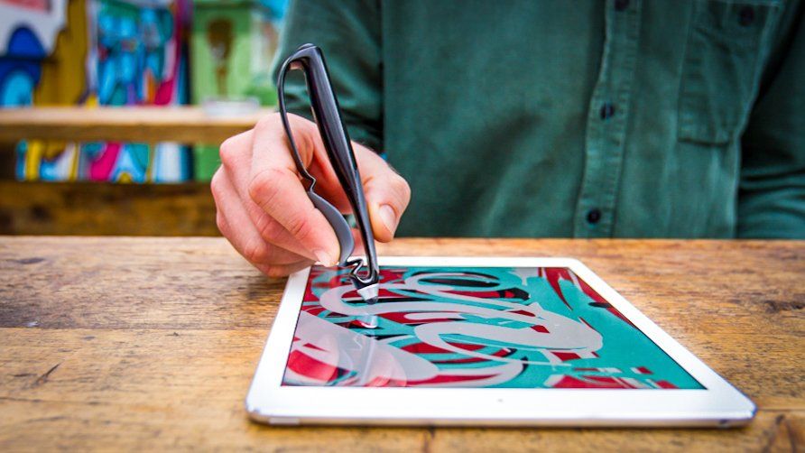 A picture of someone drawing on a touch screen device with a Scriba Stylus