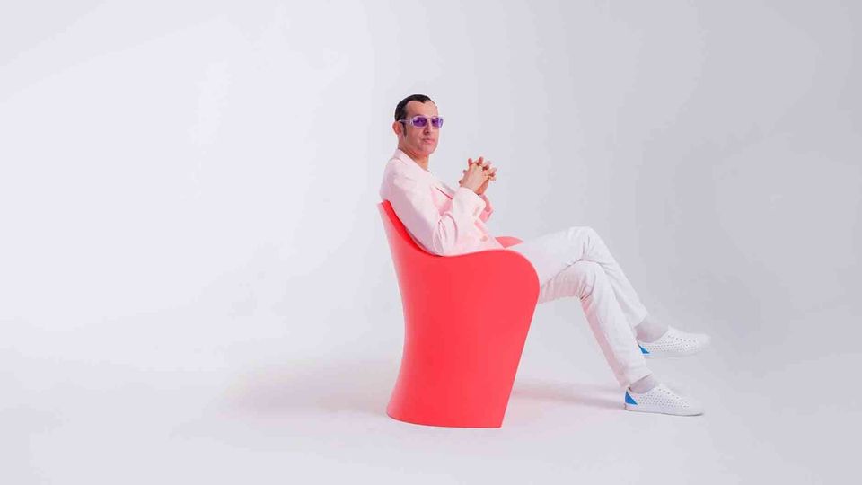 Karim Rashid sitting in a chair