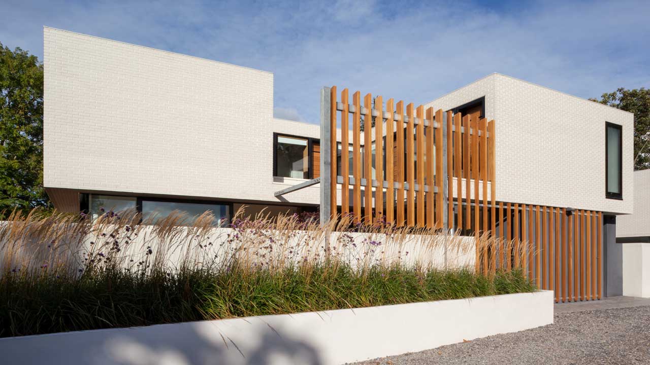 Contemporary glass facade of a home in Clontarf featuring white brick accents