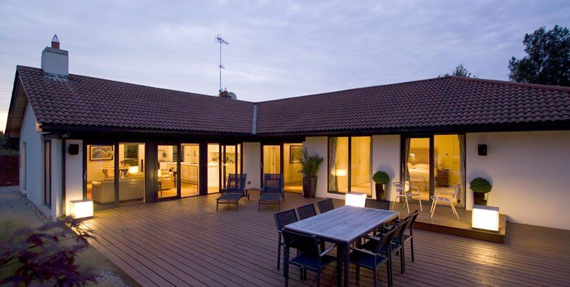 A patio with a table and chairs in front of a house