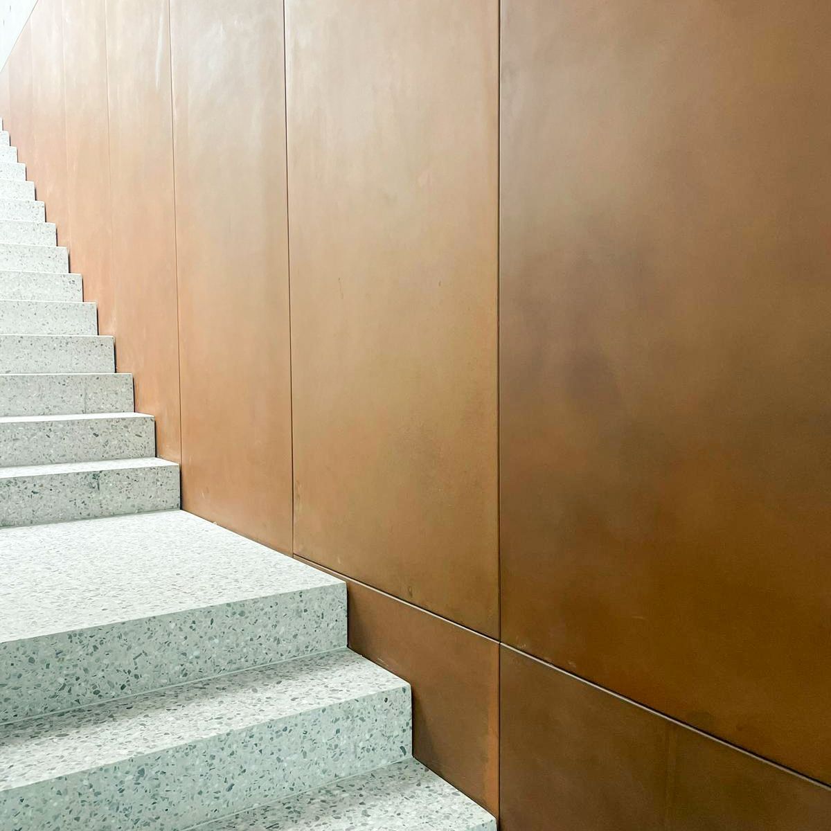 A set of stairs leading up to a brown wall.