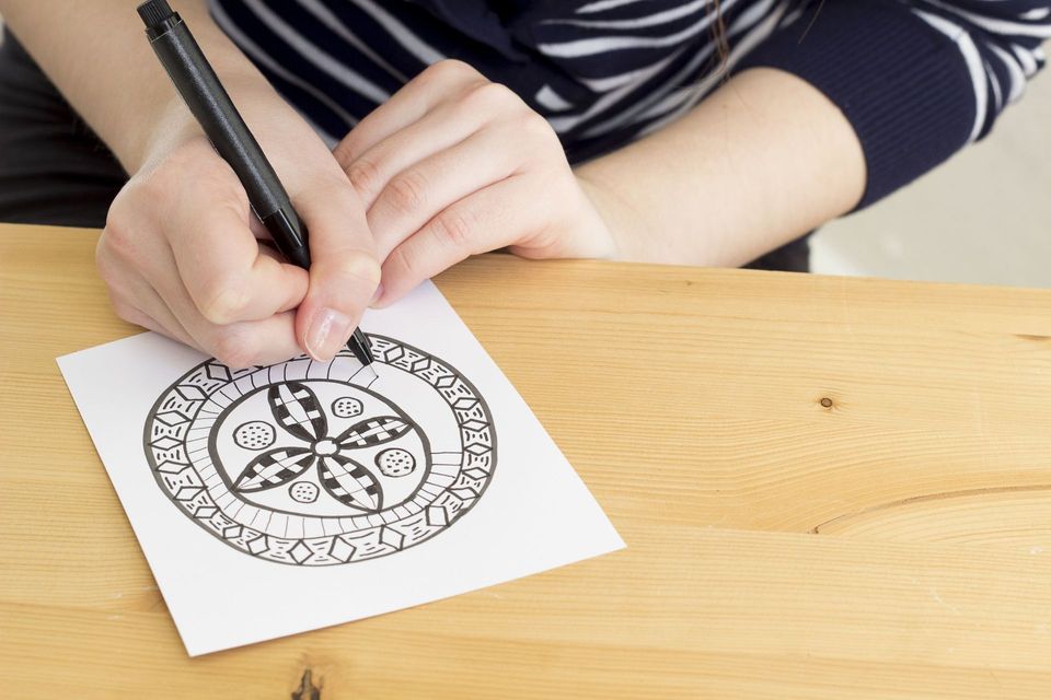 Someone drawing a design with a pen
