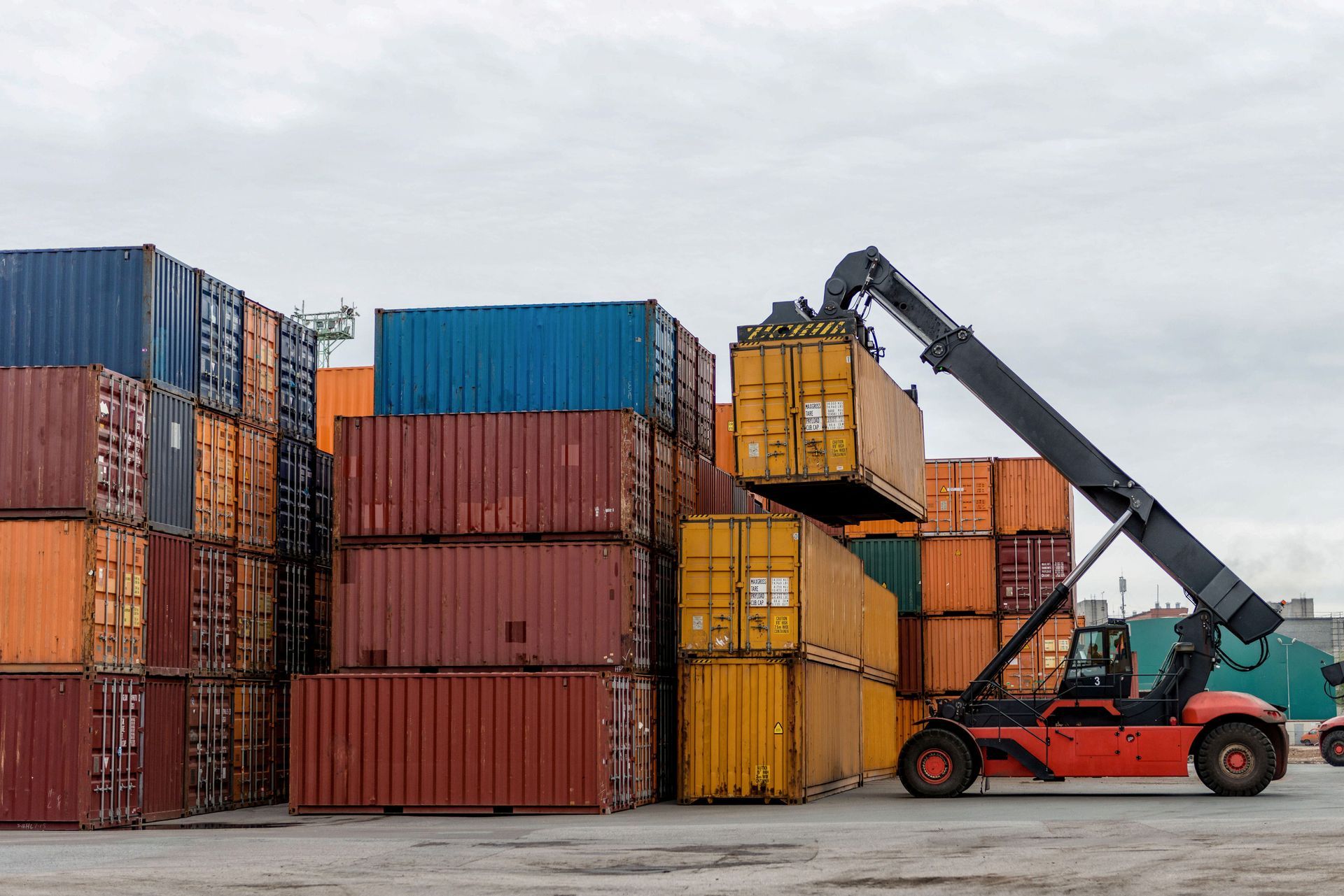 Mobile stacker handler in action at a container terminal.