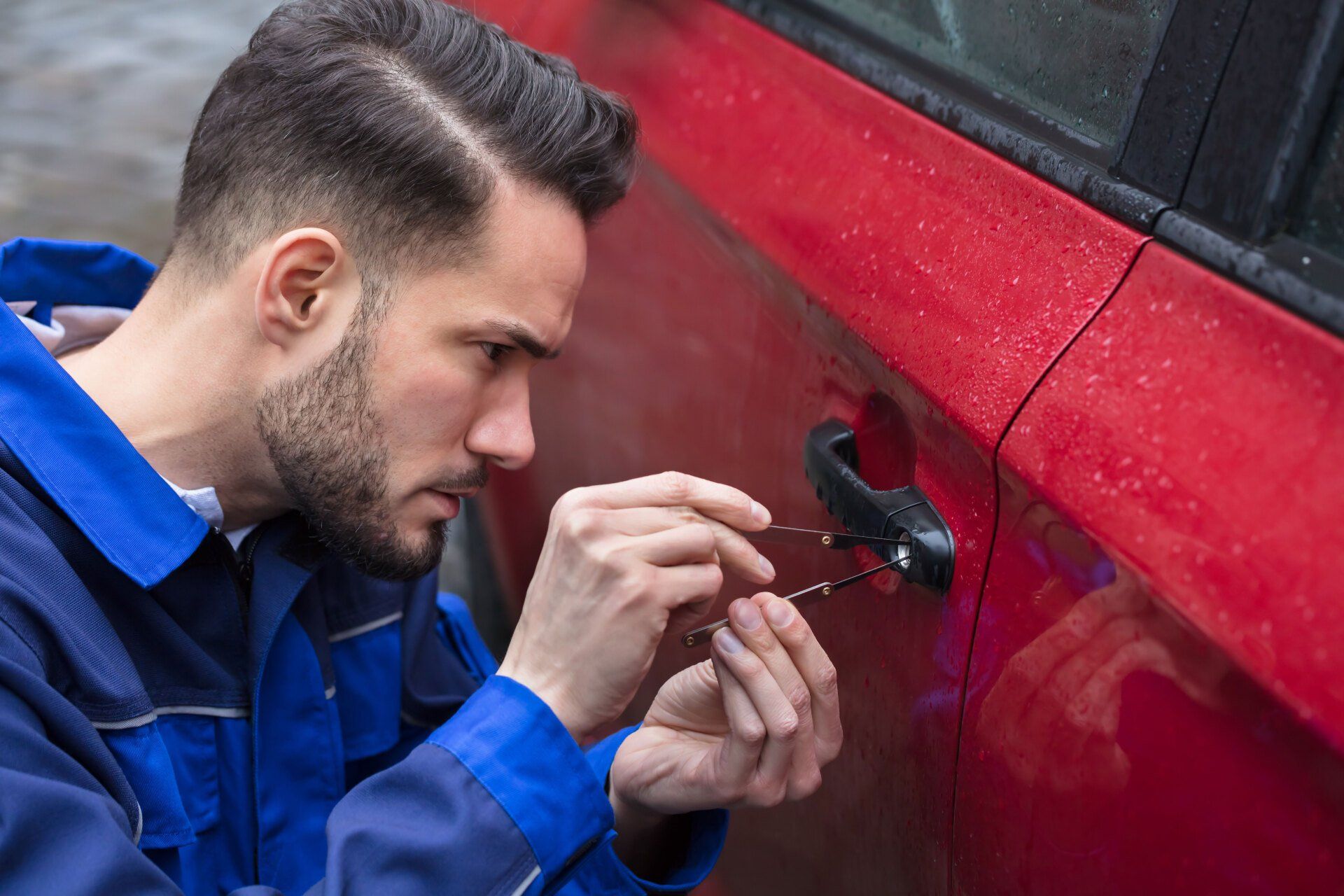 Car Technician opening a locked car door