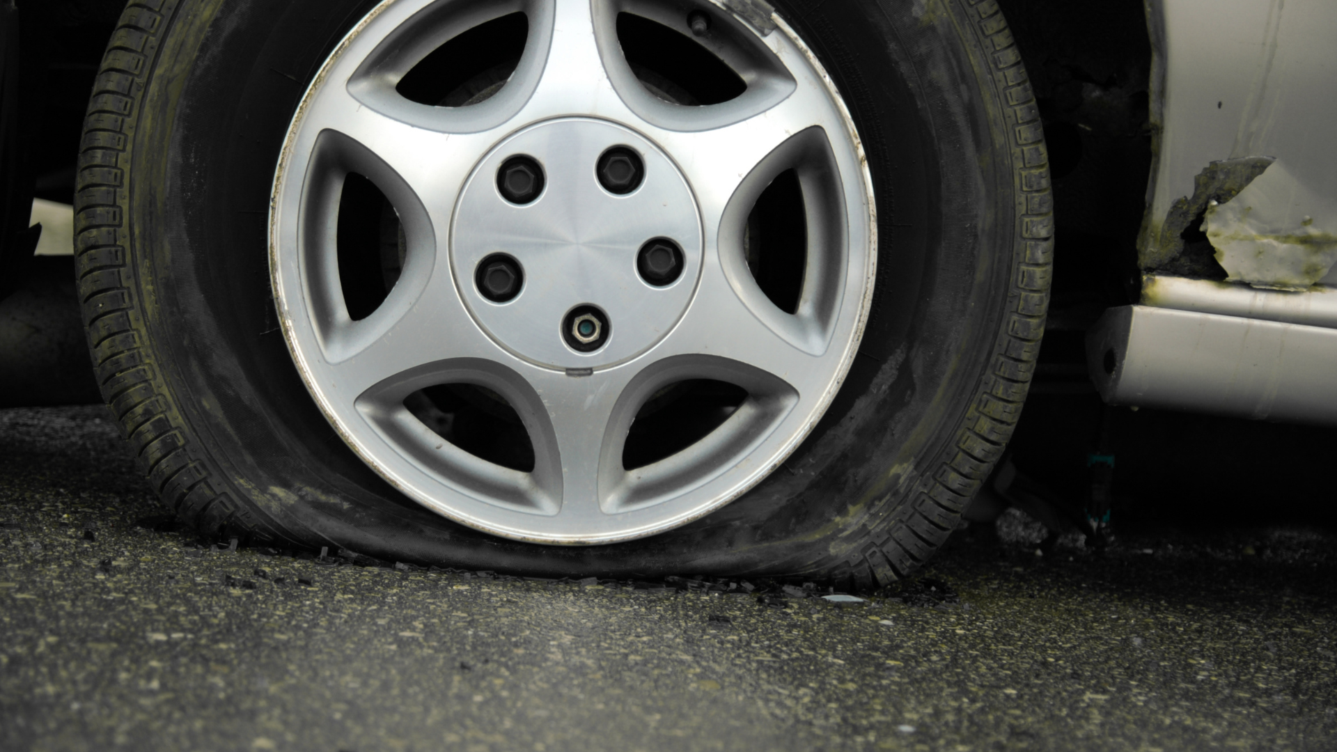 A close up of a flat tire on a car.