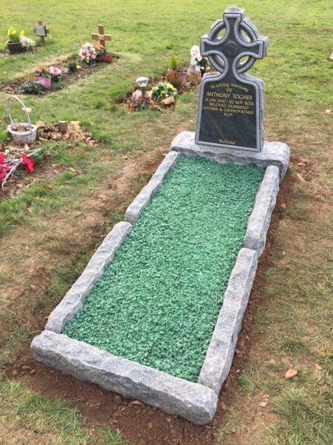 gray full memorial made to look weathered with green pebbles