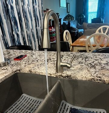 Kitchen faucet with running water in a double sink.