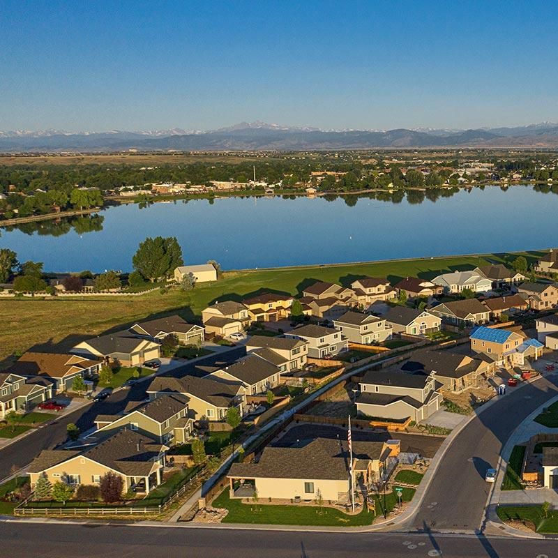 An aerial view of a residential area with a lake in the background.