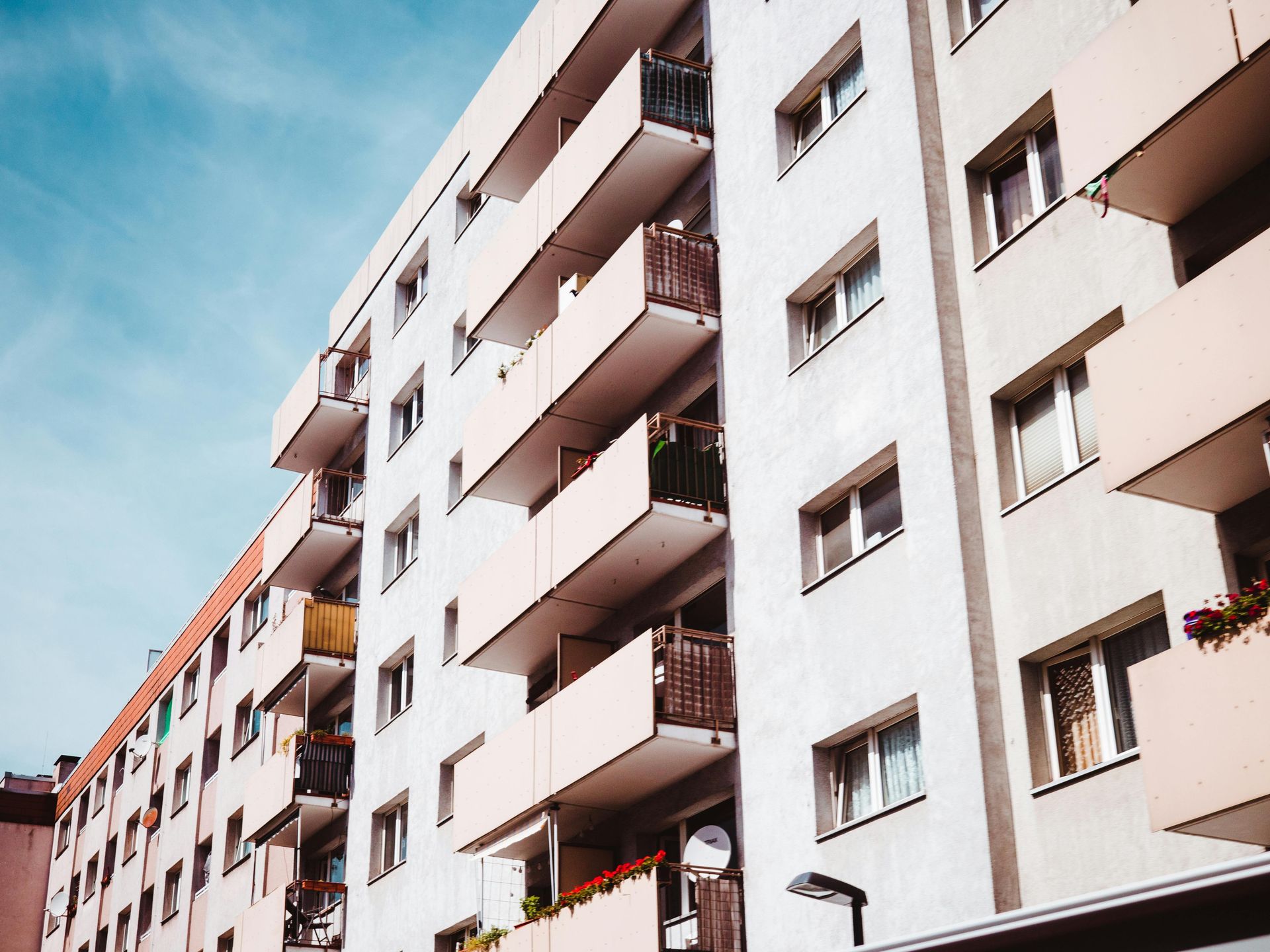 A row of apartment buildings with balconies against a blue sky