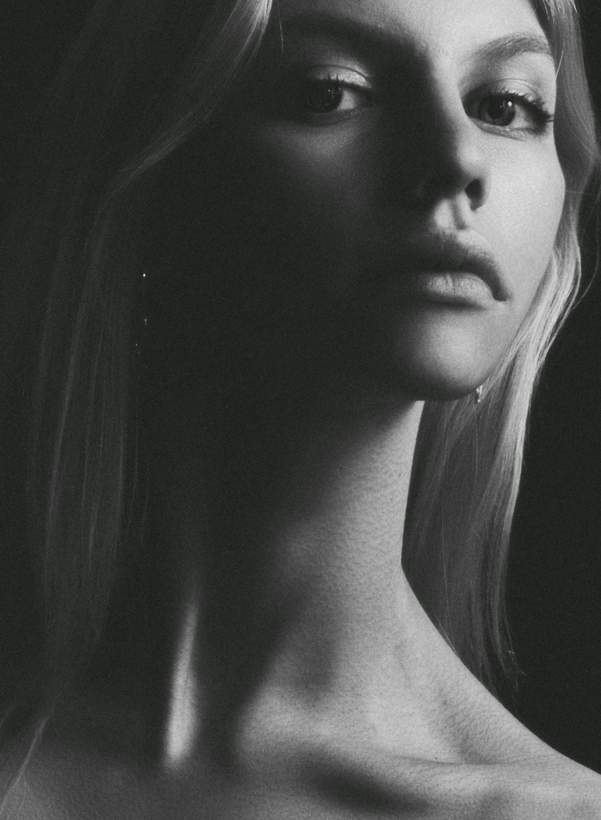 A black and white photo of a woman 's neck and face.