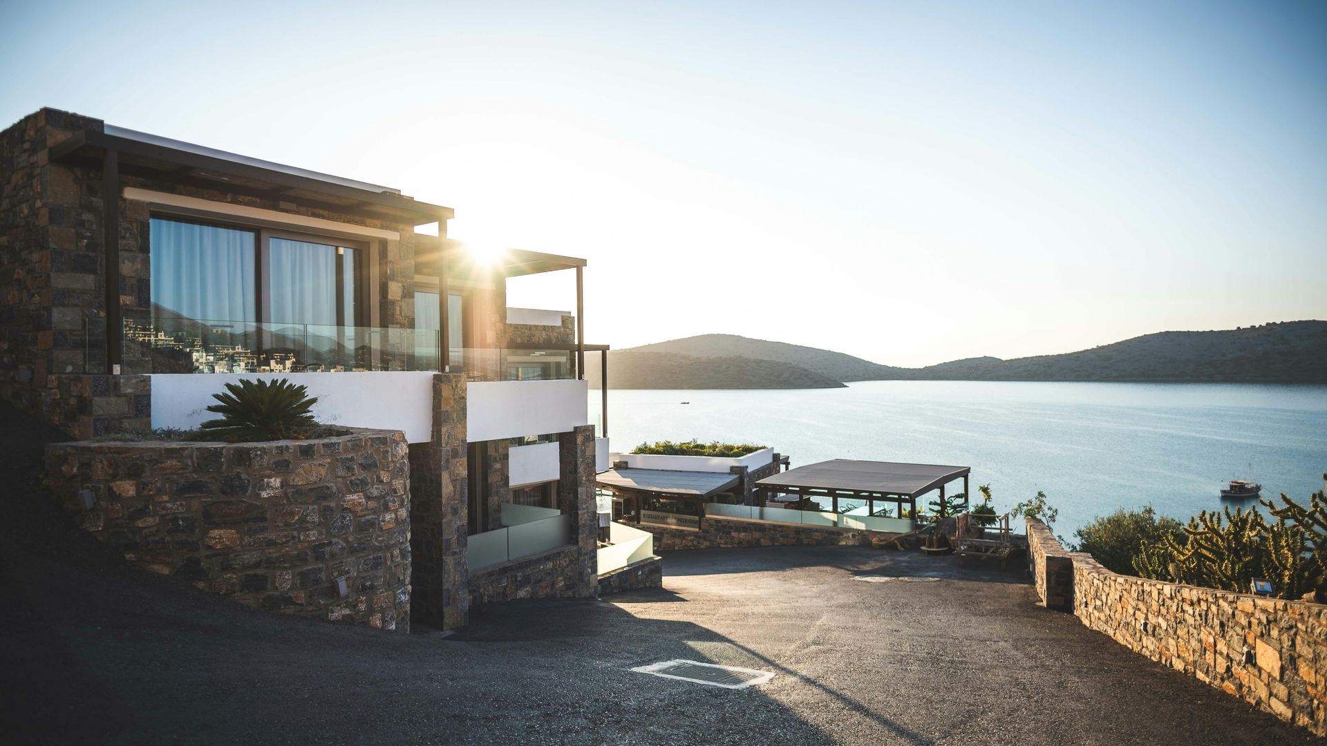 A large house is sitting on top of a hill overlooking the ocean.