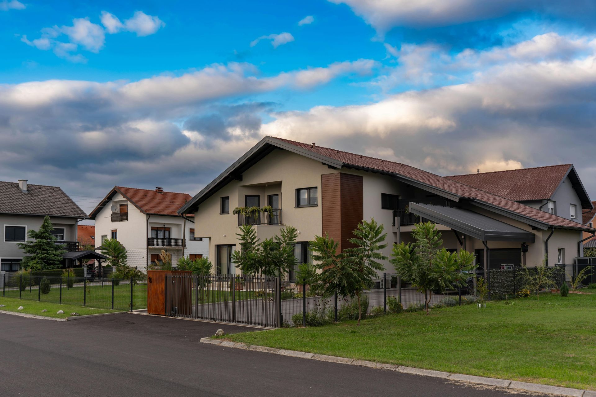 A row of houses in a residential area with a cloudy sky in the background.