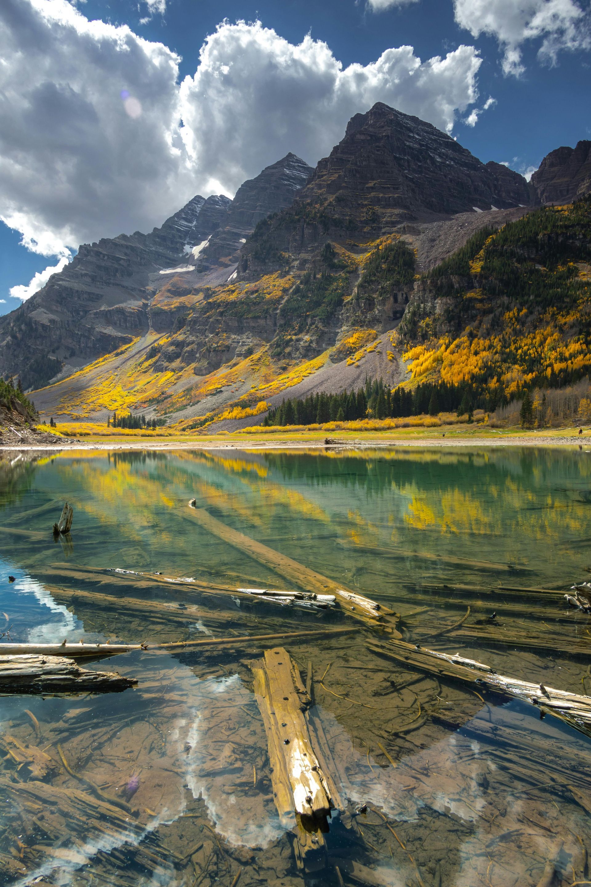 A lake with mountains in the background and a log in the foreground.