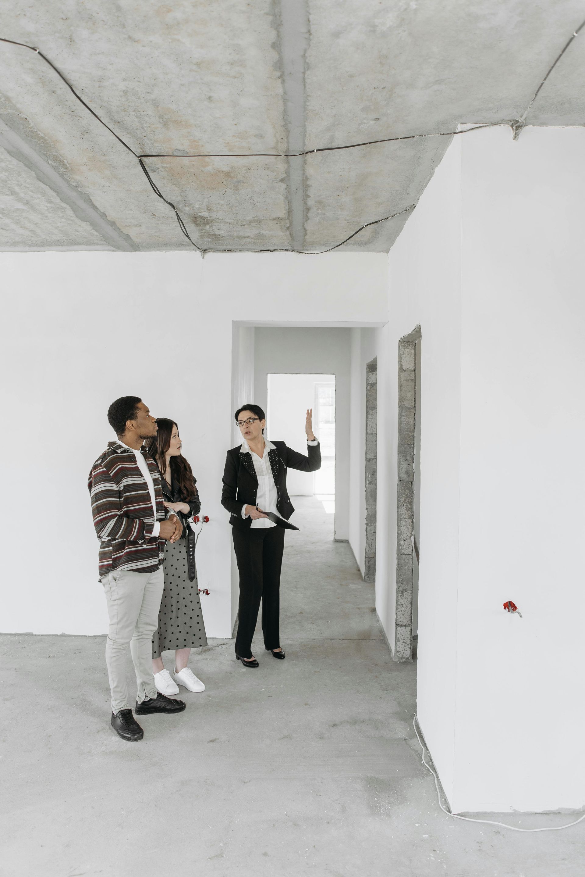 A man and a woman are standing in an empty room.