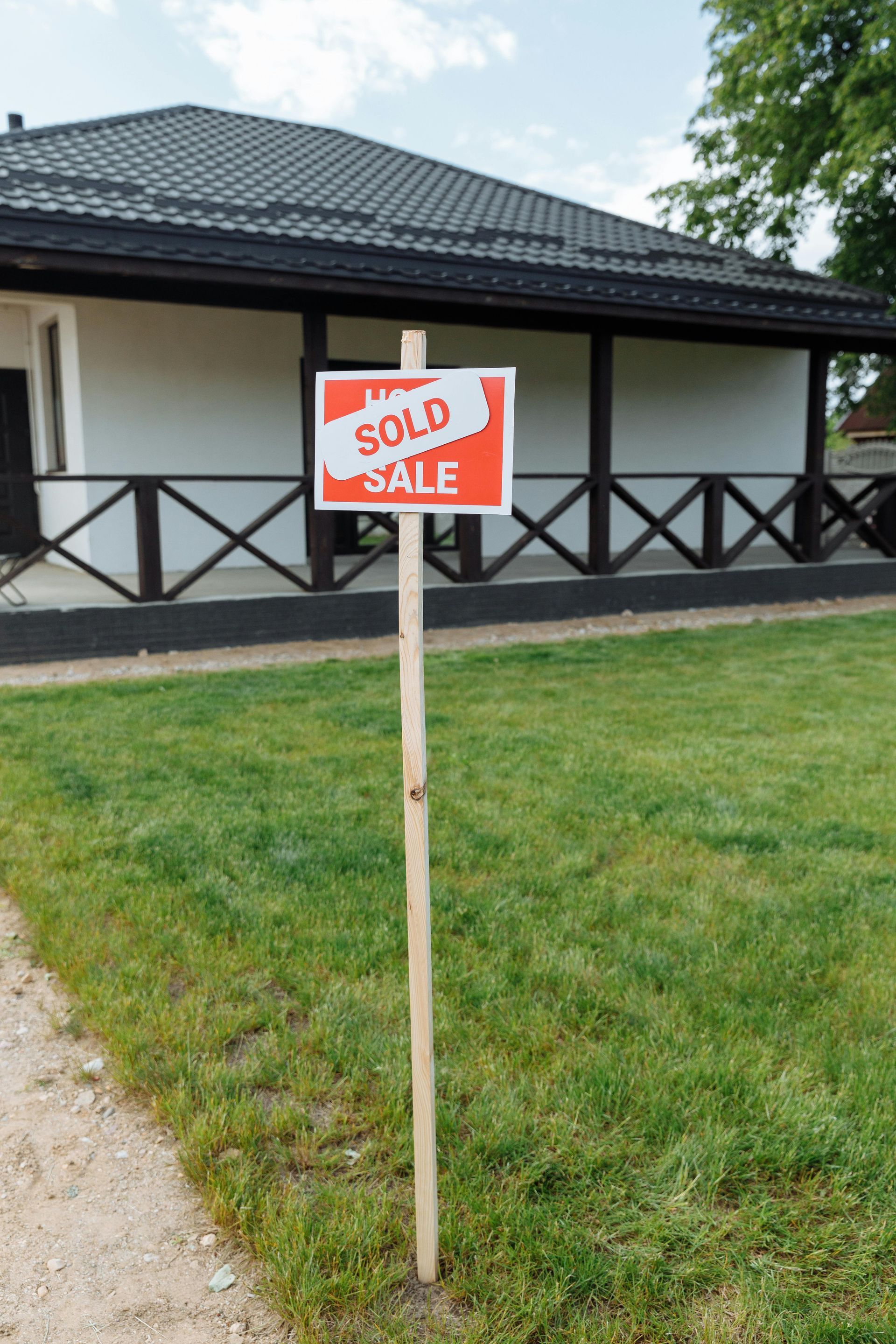 A sold sign is sitting in front of a house.