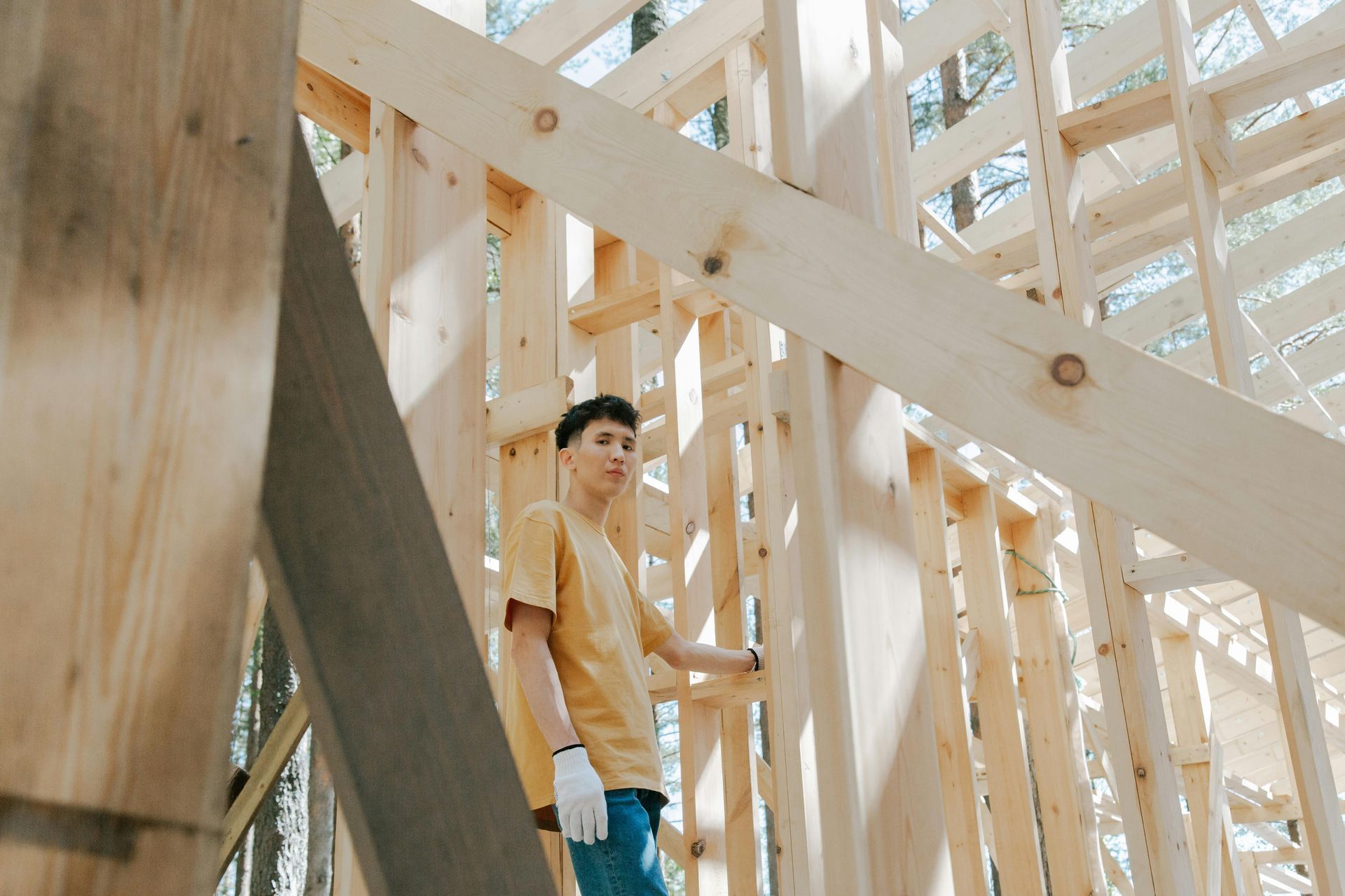 A man is standing in a wooden structure under construction.