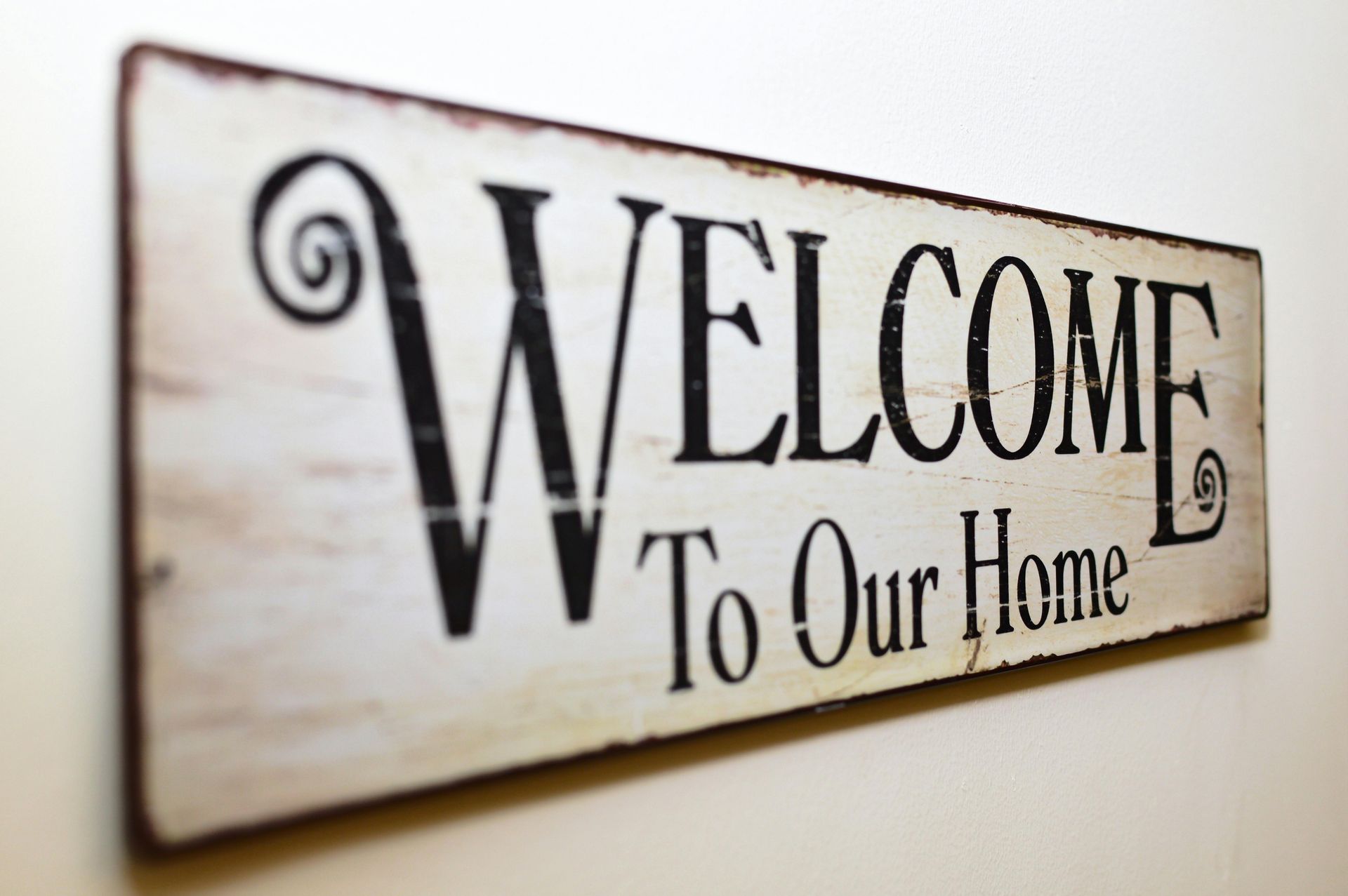 A sign that says welcome to our home on it