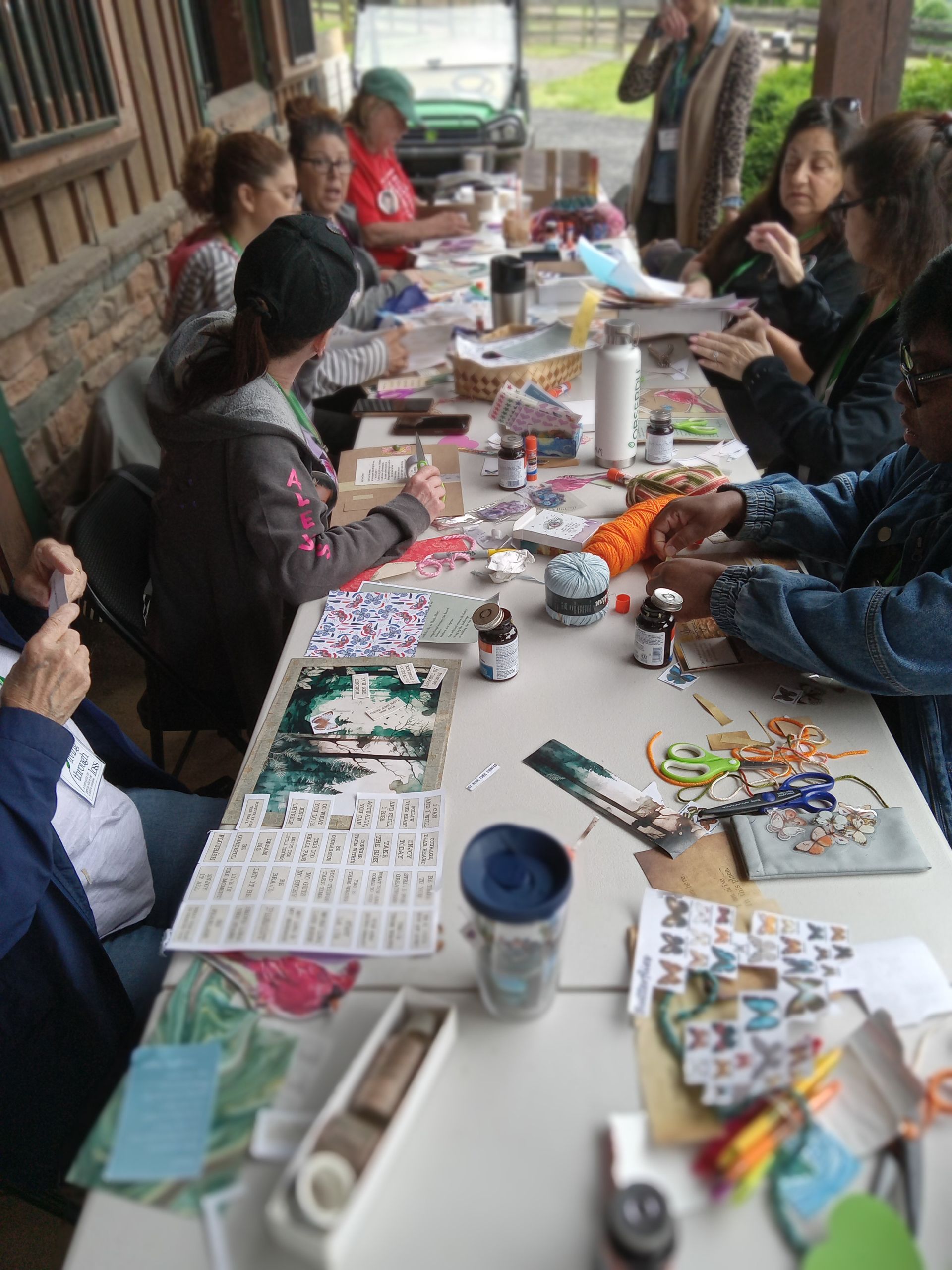 A group of people are sitting around a table making crafts