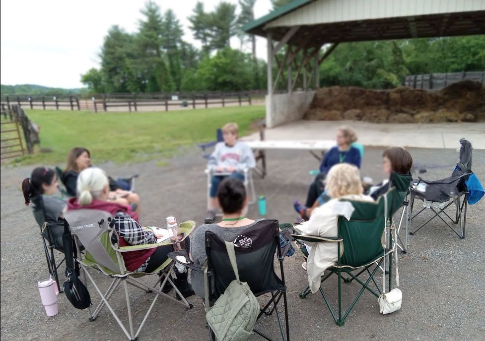 A group of people are sitting in chairs in a circle