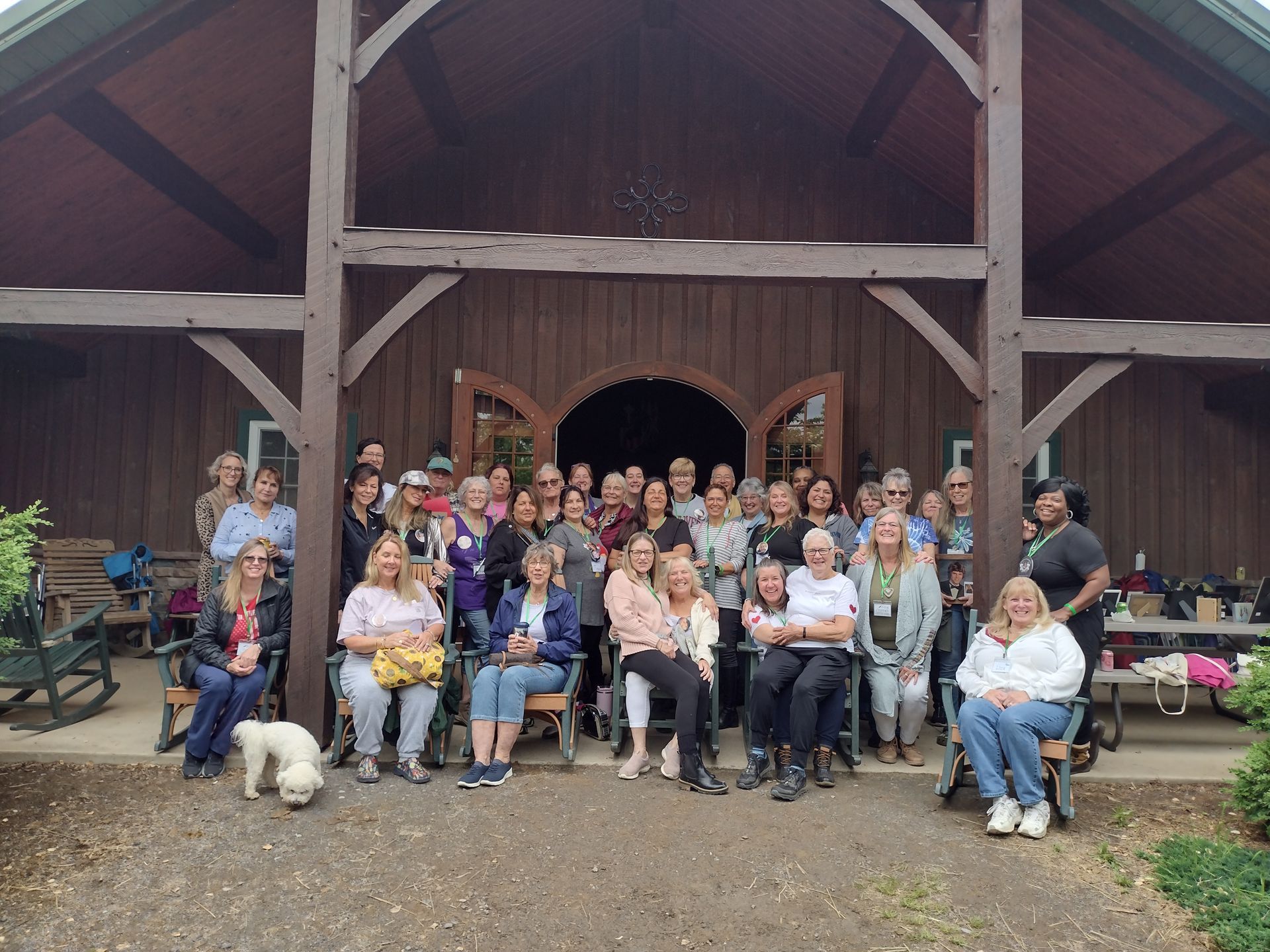 A group of people are posing for a picture in front of a barn.